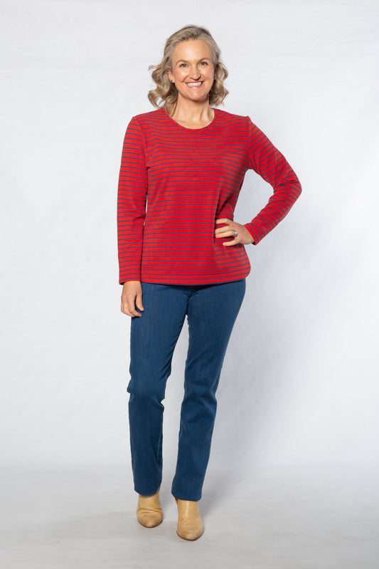 Woman wearing a red striped top and blue jeans on a white background