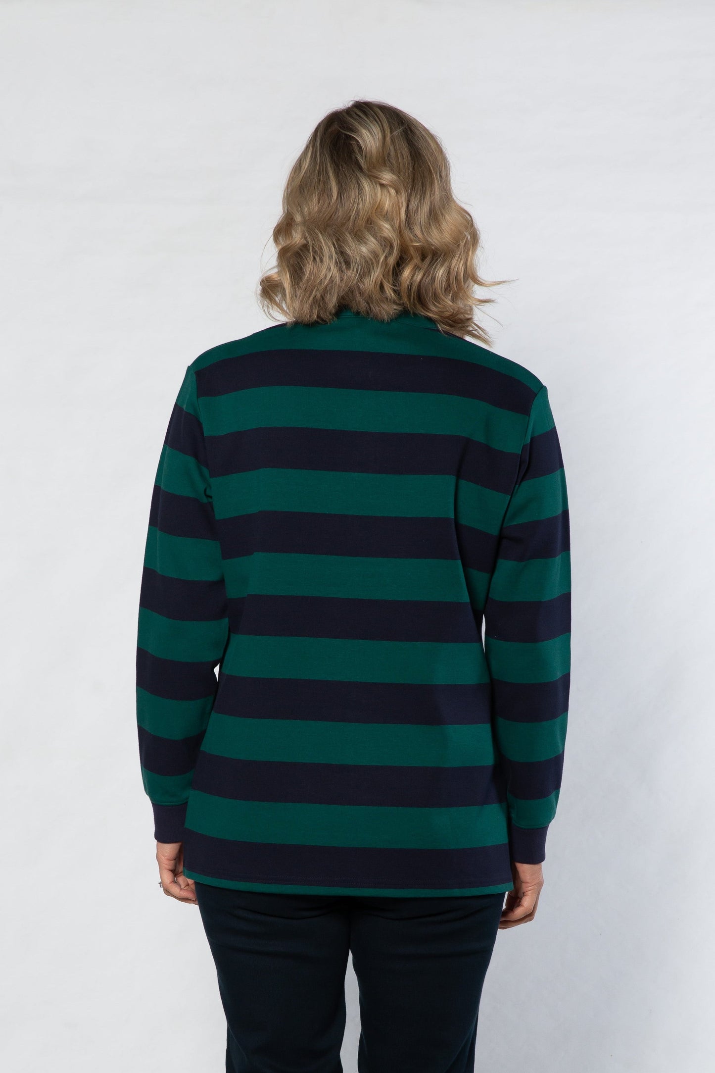Person wearing a green and navy striped sweater against a white background