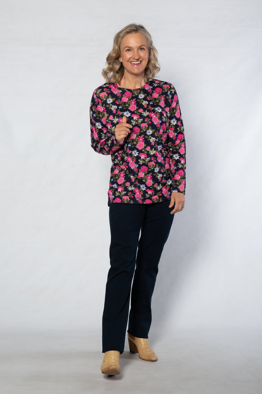 Woman wearing a floral blouse and black pants on a white background