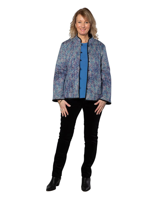 Model wearing Equinox Clothing reversible blue and black oriental jacket with patch pockets and button-up front.