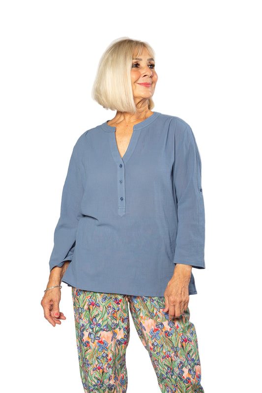 Woman wearing a blue top and floral pants on a white background