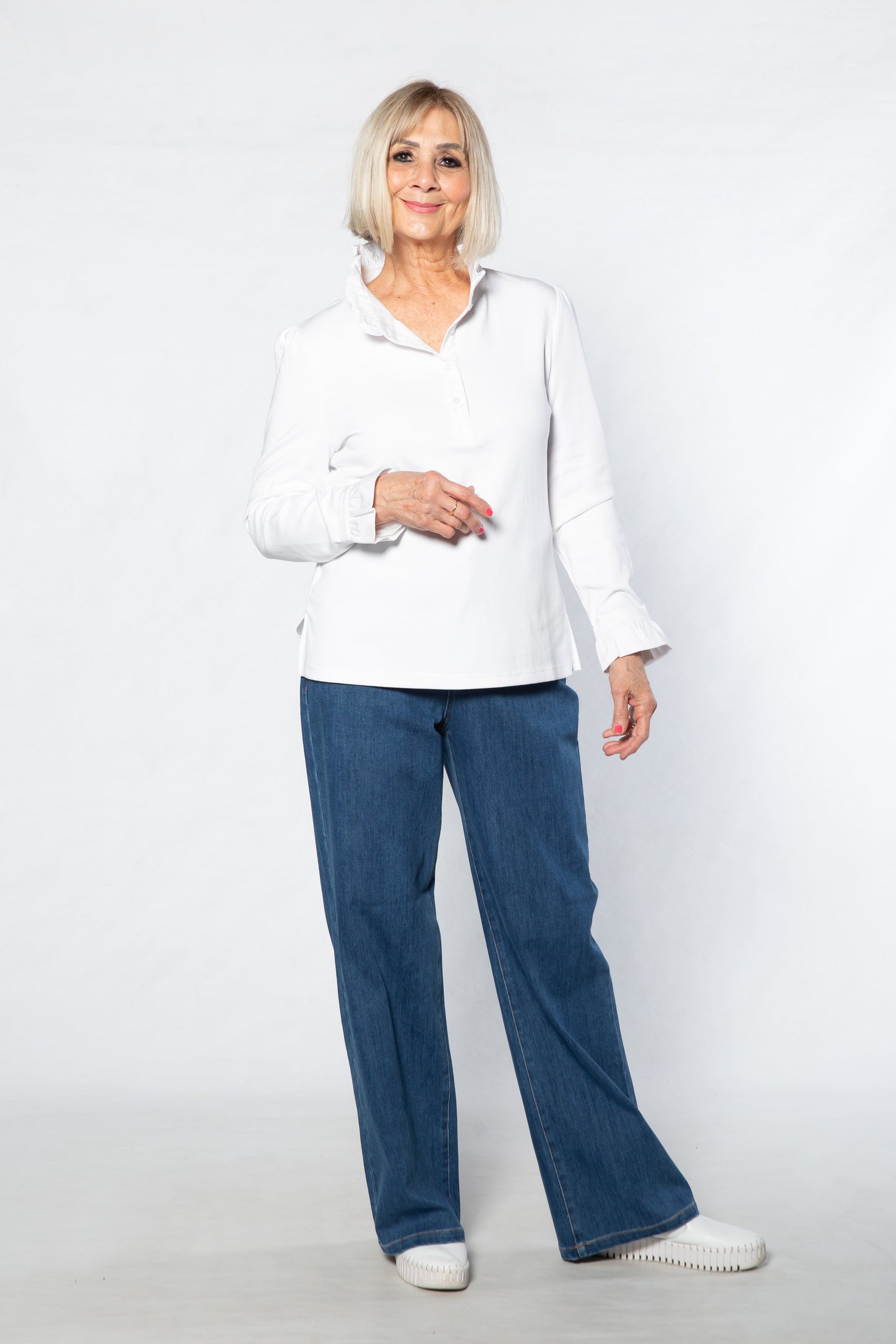 Woman wearing a white shirt and blue jeans on a white background