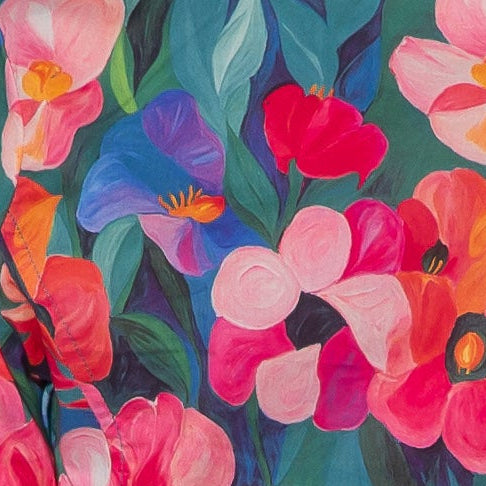 Person wearing a colorful floral blouse and black pants on a white background