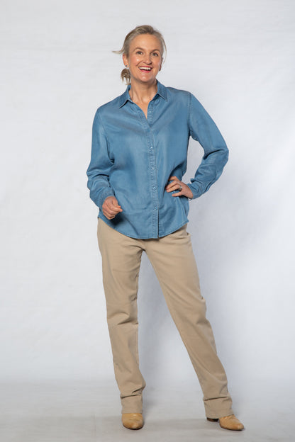 Person wearing a blue shirt and beige pants on a white background