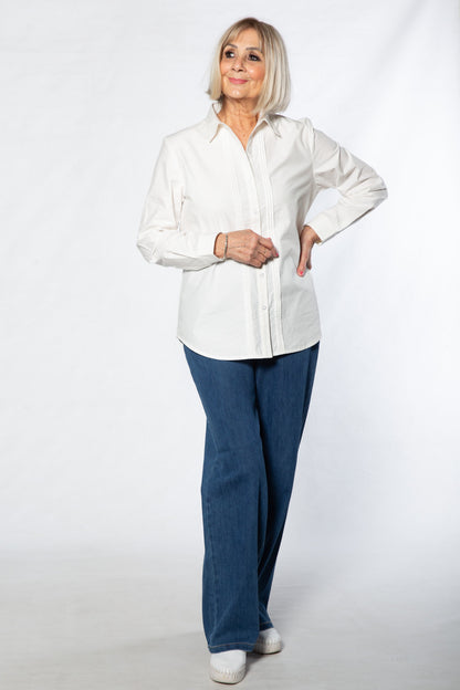 Person wearing a white shirt and blue pants standing against a white background