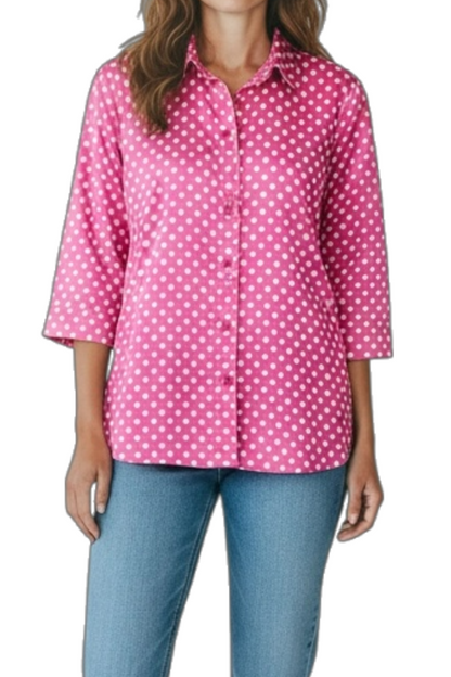 Woman wearing a pink polka dot shirt and blue jeans on a white background