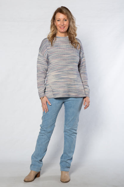 Woman wearing a striped sweater and blue jeans on a white background
