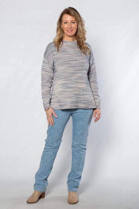 Woman wearing a striped sweater and blue jeans on a white background