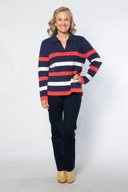 Woman wearing a striped sweater and dark pants on a white background