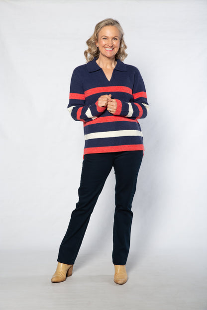 Woman wearing a striped sweater and dark pants on a white background