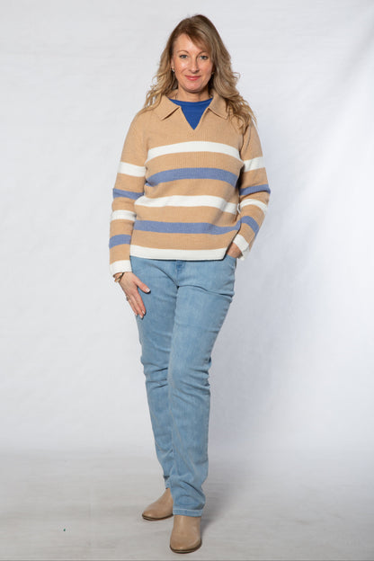 Woman wearing a striped sweater and blue jeans on a white background