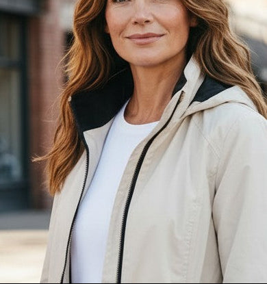 A woman modeling a light beige hooded jacket in four outdoor urban views: full front, back, and side views, plus a close-up portrait. The jacket appears off-white/cream with a dark hood lining and dark zipper trim.