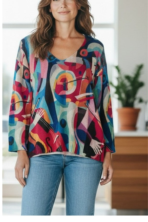 Woman wearing an Equinox Clothing lightweight V-neck sweater with a vibrant abstract Musica print and long sleeves.