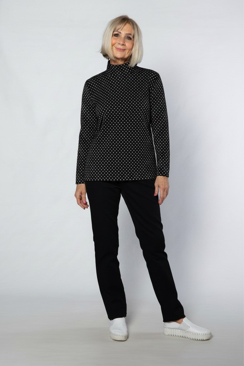 Equinox Clothing model wearing a black and white spot print mock turtle skivvy in a soft cotton blend fabric