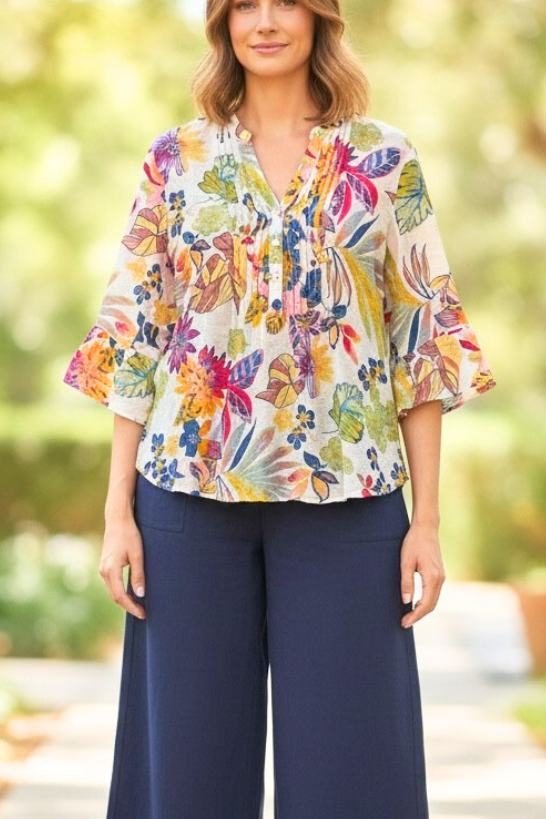 Equinox Clothing white multi floral print shirt with 3/4 bell sleeves and pleat front detail worn by a woman