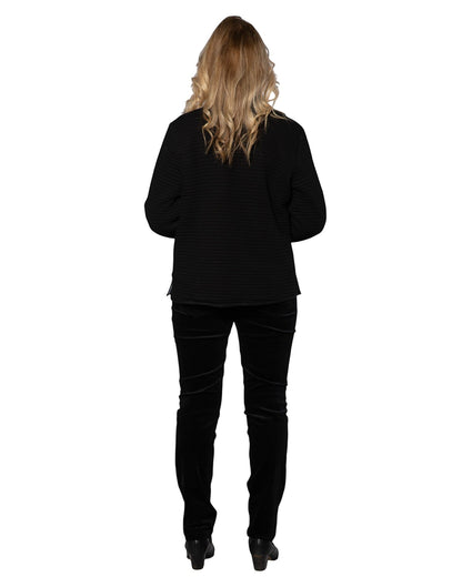 Model wearing Equinox Clothing reversible oriental jacket in black with textured fabric, paired with black trousers.