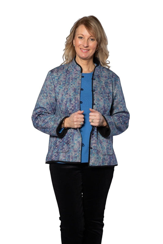 Model wearing Equinox Clothing reversible blue oriental jacket with patch pockets and black trim on white background.