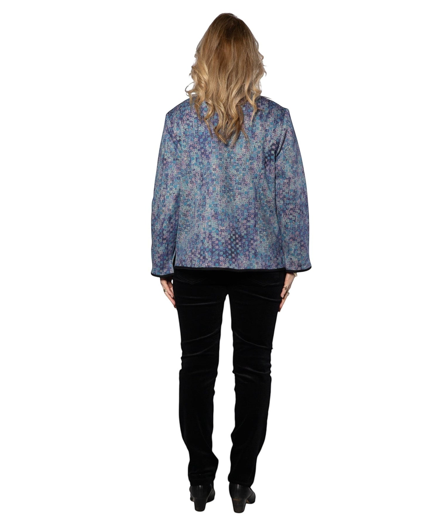 Model wearing Equinox Clothing blue reversible oriental jacket with geometric print, paired with black trousers.