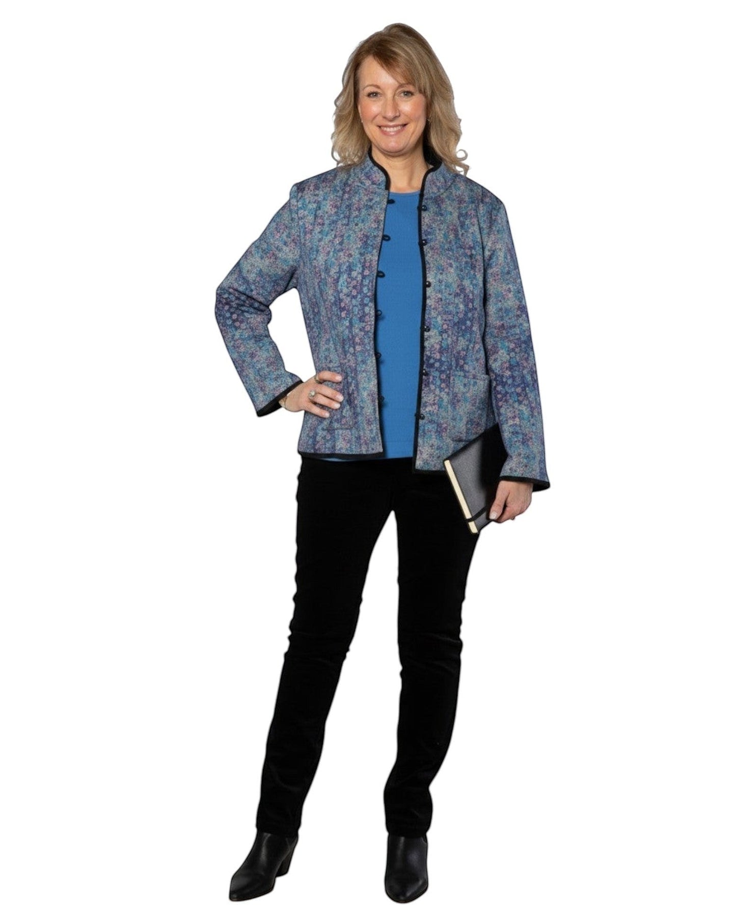 Model wearing Equinox Clothing reversible oriental jacket in blue floral print with black trim and patch pockets.