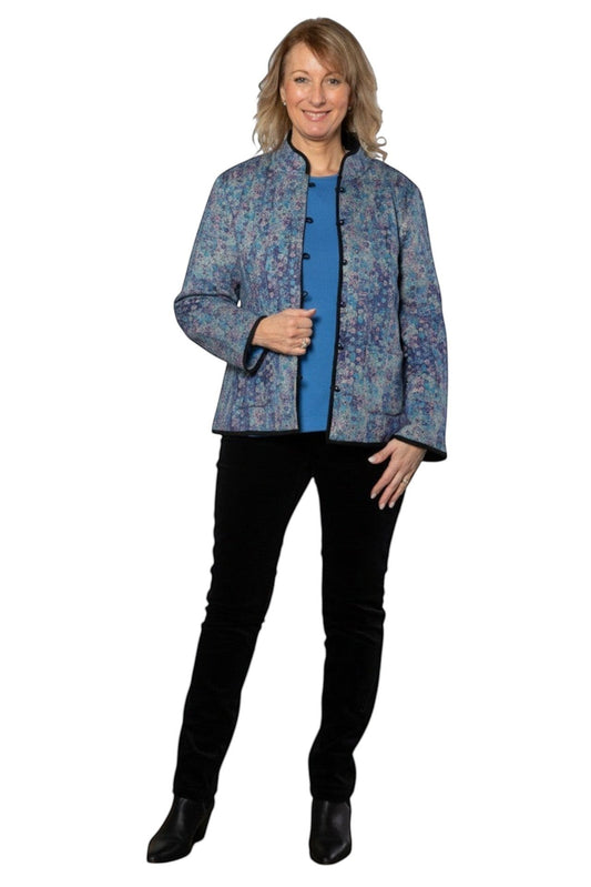 Model wearing Equinox Clothing reversible blue and black oriental-style jacket with patch pockets in an art gallery.