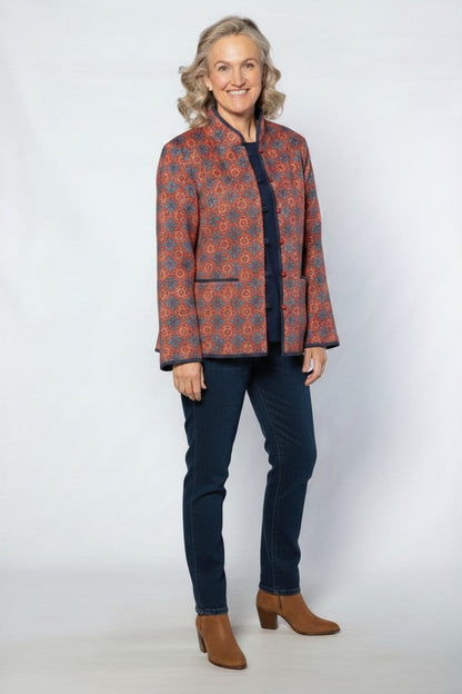 Model wearing Equinox Clothing reversible oriental jacket in red and navy with quilted fabric and button loop closure.