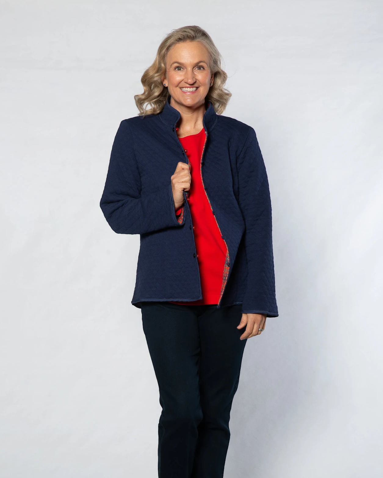 Model wearing Equinox Clothing reversible oriental jacket in navy and red quilted cotton blend with button closure.