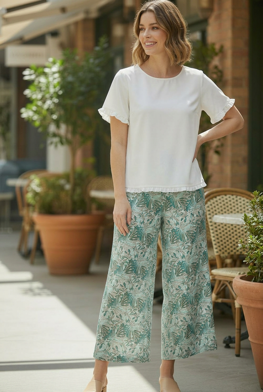 Model wearing Equinox Clothing green Palm Print wide leg pull-on culottes #6670 with a white top, full-length angled pose.