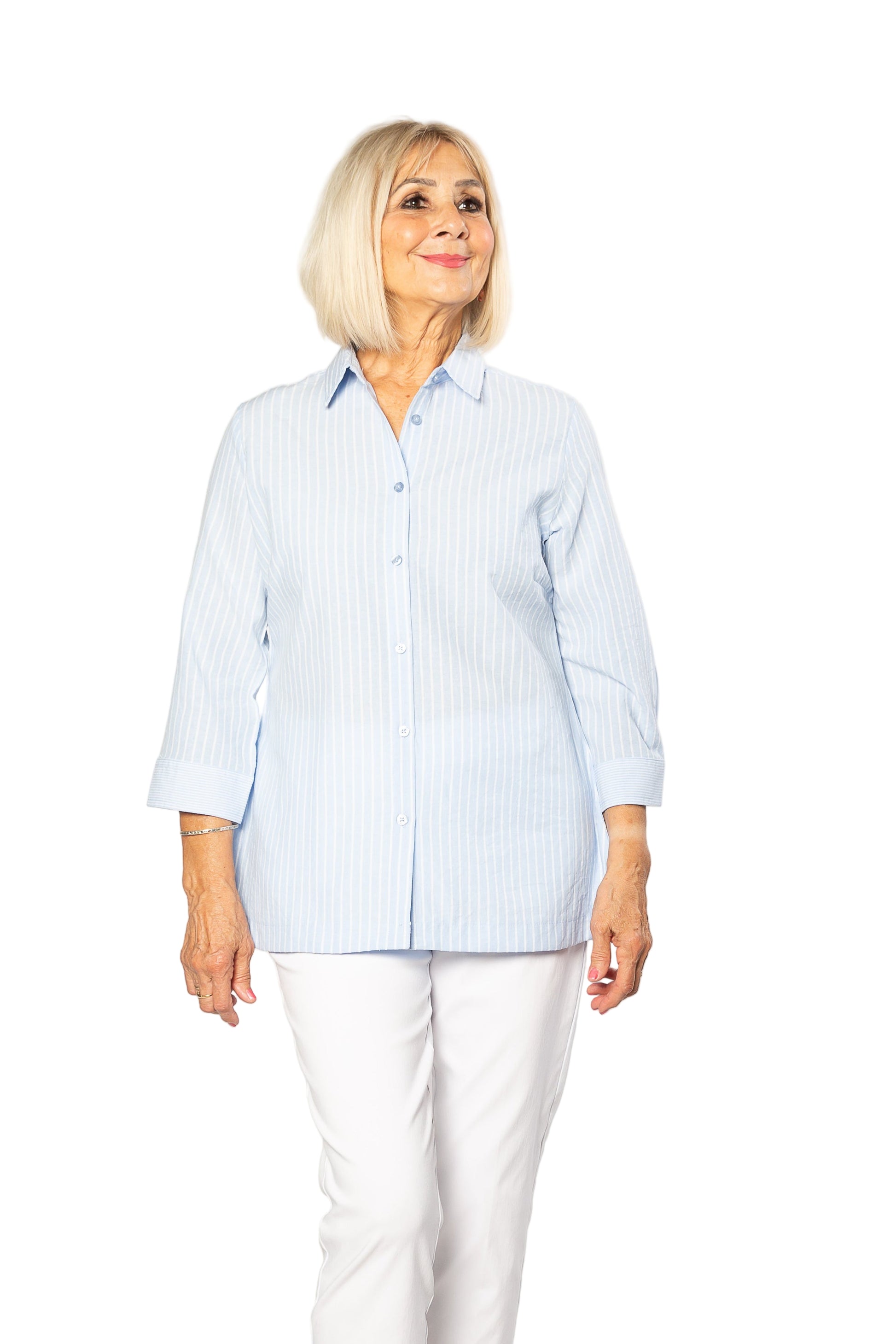 Woman wearing a light blue striped shirt and white pants on a white background
