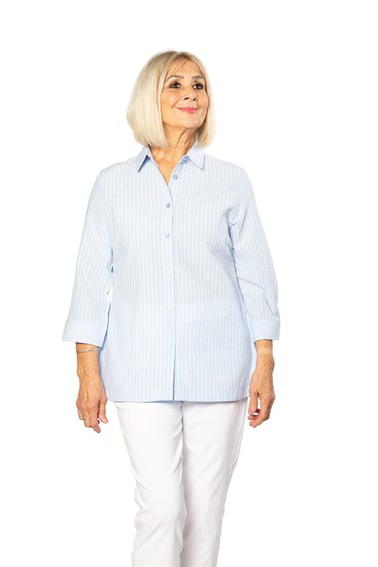 Woman wearing a light blue striped shirt and white pants on a white background